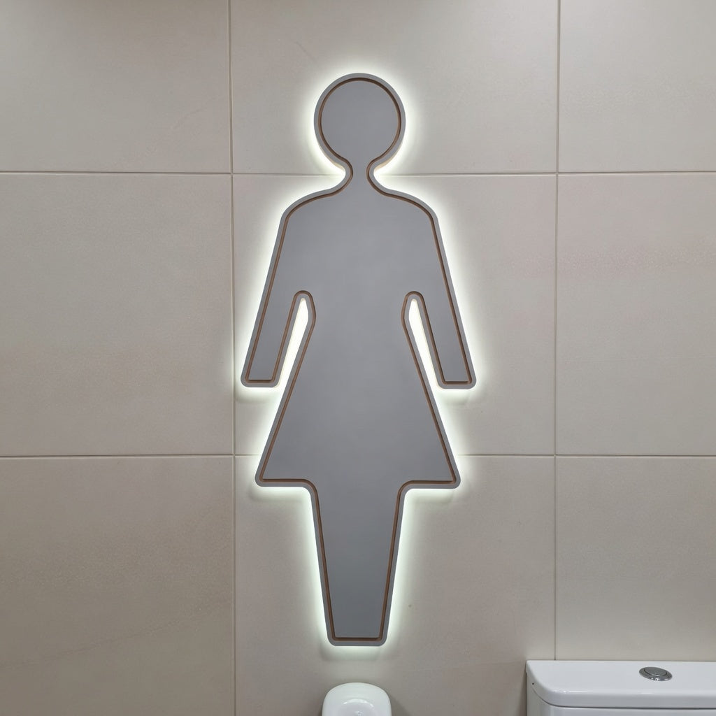Illuminated female bathroom silhouette toilet sign on a tiled wall with an led glow behind it